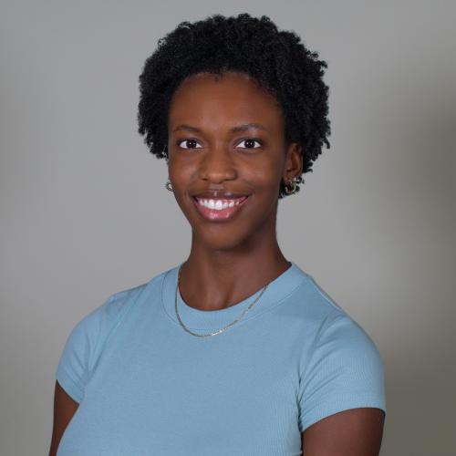 A woman with a blue shirt and black hair smiling at the camera.