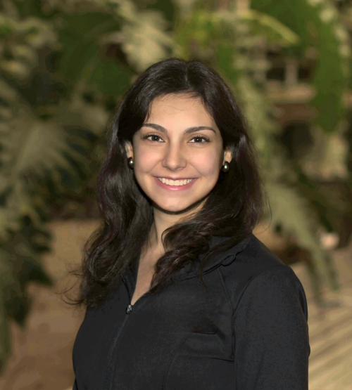 A woman with black hair and a black shirt smiles at the camera